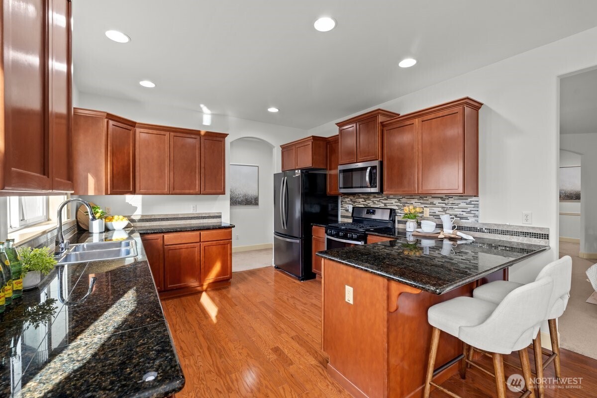 603 194th Place Southeast Bothell, WA 98012 - Photo 10 of 30 a kitchen with stainless steel appliances granite countertop a sink stove and refrigerator