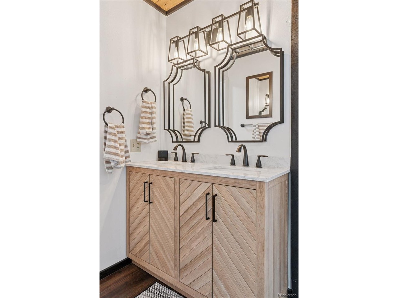 16880 Old Pueblo Road Fountain, CO 80817 - Photo 14 of 49 En-suite bathroom with dual sinks, updated vanity cabinetry, and modern lighting fixtures.