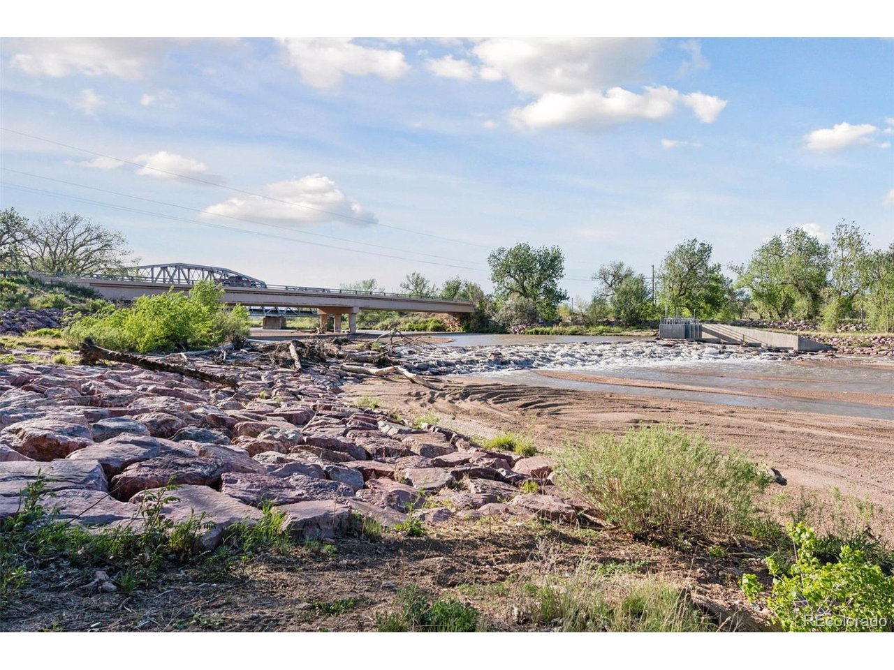 16880 Old Pueblo Road Fountain, CO 80817 - Photo 42 of 49 Fountain Creek corridor near Old Pueblo Road and Hanover Road, showcasing the natural riparian setting, rock-lined banks, and nearby bridge crossing