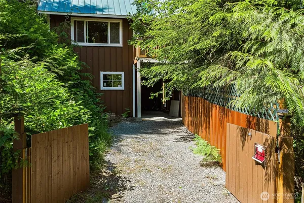 a view of a house with a yard plants and large tree