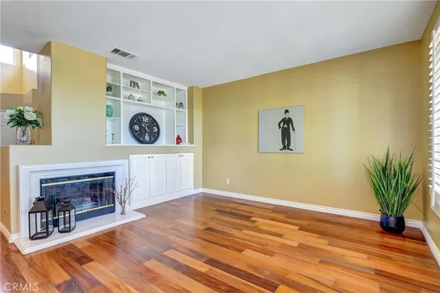 a view of a livingroom with wooden floor and a fireplace