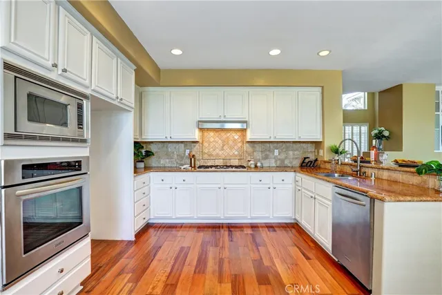 a kitchen with granite countertop stainless steel appliances and wooden cabinets