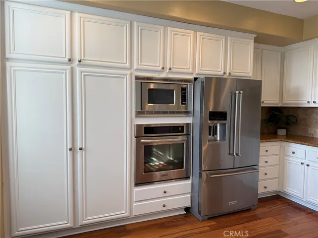 a kitchen with granite countertop white cabinets and stainless steel appliances