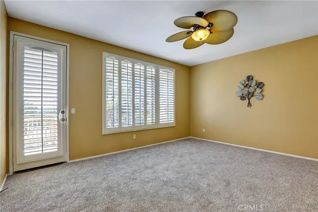 a view of an empty room with a window and a chandelier