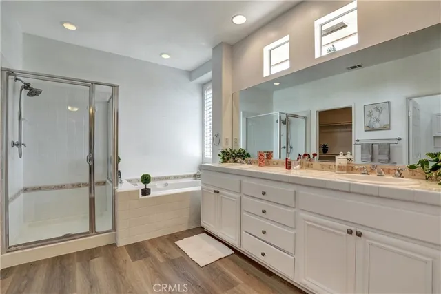 a spacious bathroom with a double vanity sink a mirror and a bathtub