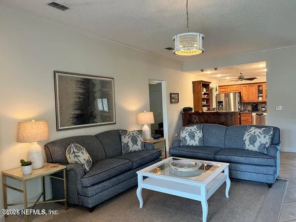 a living room with furniture a dining table and a chandelier
