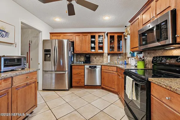 a kitchen with stainless steel appliances granite countertop a refrigerator stove top oven a sink and dishwasher