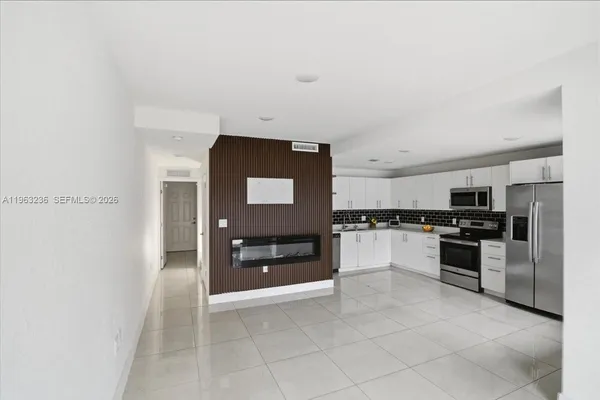 a large kitchen with cabinets and stainless steel appliances