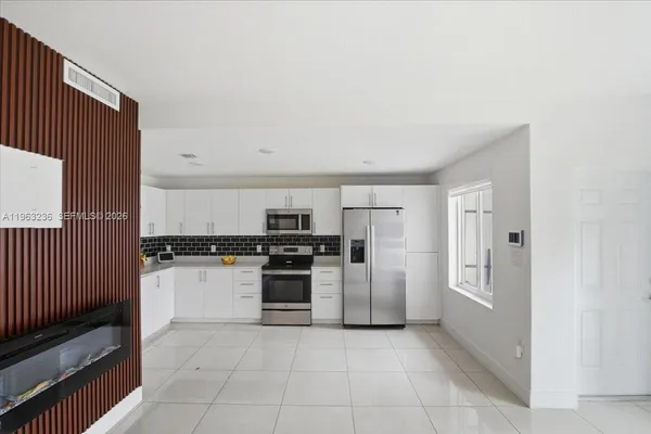 a kitchen with stainless steel appliances granite countertop a refrigerator and a stove