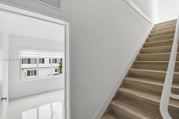 a view of staircase with wooden floor and a potted plant