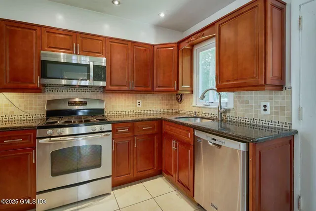 a kitchen with stainless steel appliances granite countertop a stove sink microwave and cabinets