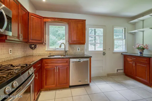 a kitchen with stainless steel appliances granite countertop a stove sink and cabinets