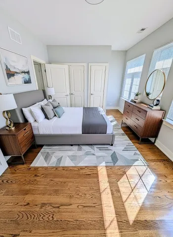 a bedroom with a bed and wooden floor