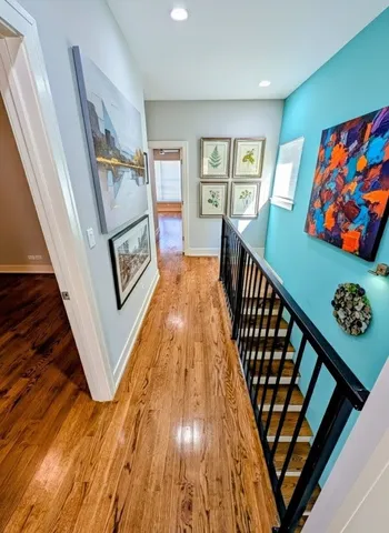 a view of a hallway with wooden floor and staircase