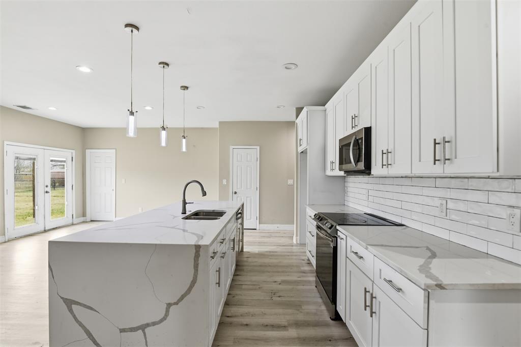 2204 Albert Broadfoot Street Bonham, TX 75418 - Photo 1 of 39 a kitchen with stainless steel appliances granite countertop a sink a stove and a wooden floors