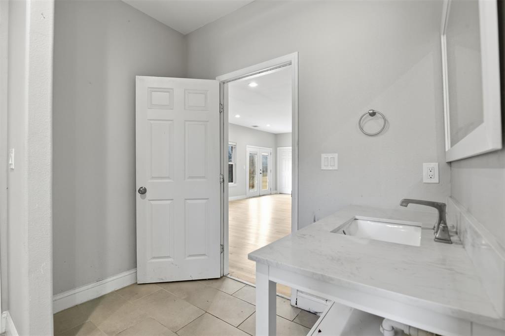 2204 Albert Broadfoot Street Bonham, TX 75418 - Photo 27 of 39 a bathroom with a sink and mirror