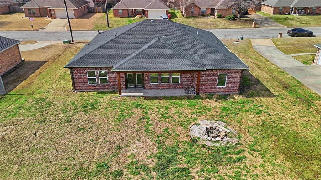 2204 Albert Broadfoot Street Bonham, TX 75418 - Photo 31 of 39 a aerial view of a house with table and chairs under an umbrella
