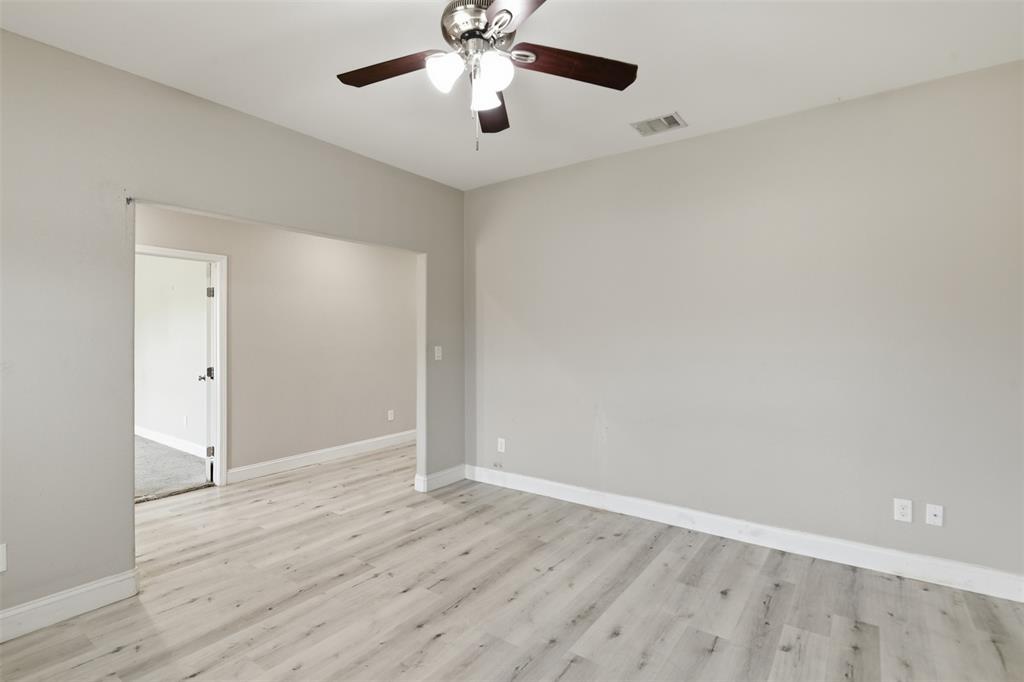 2204 Albert Broadfoot Street Bonham, TX 75418 - Photo 8 of 39 an empty room with wooden floor chandelier fan and closet area