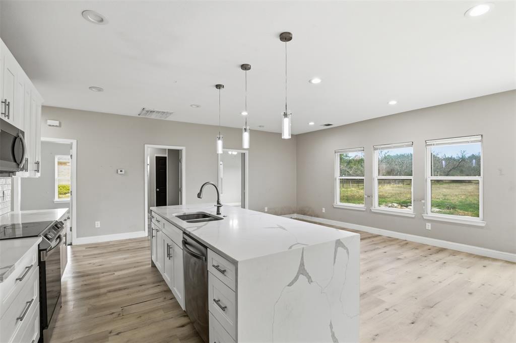 2204 Albert Broadfoot Street Bonham, TX 75418 - Photo 10 of 39 a kitchen with stainless steel appliances granite countertop a sink and a stove
