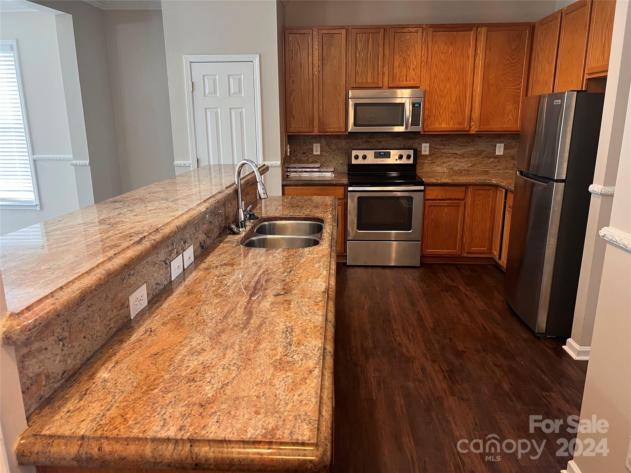 1022 Breakmaker Lane Indian Trail, NC 28079 - Photo 5 of 20 a kitchen with granite countertop wooden floors stainless steel appliances and a window