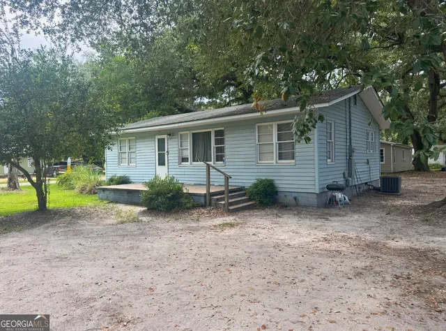 a view of a house with a backyard and a tree