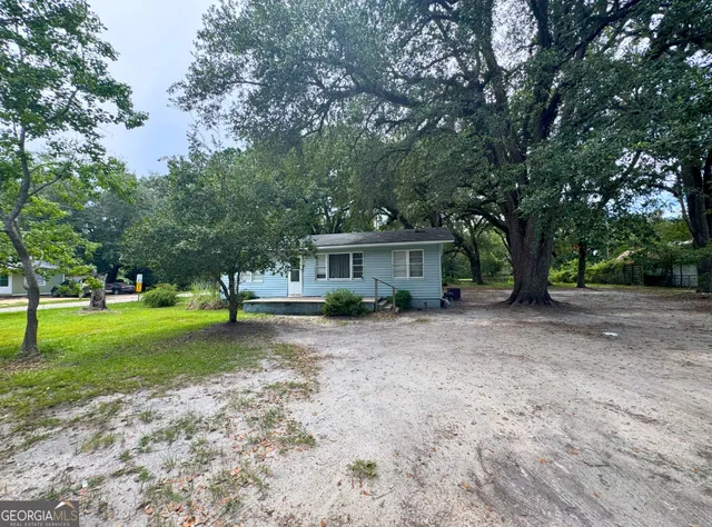 a front view of a house with a yard and trees