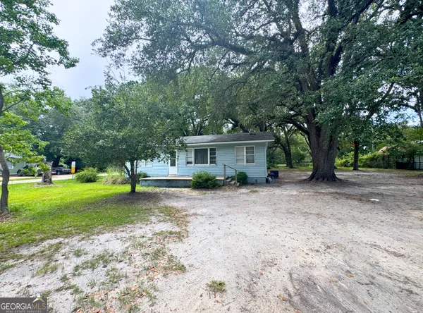 a view of a house with a yard and tree s
