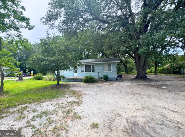 a view of a house with a yard and tree s