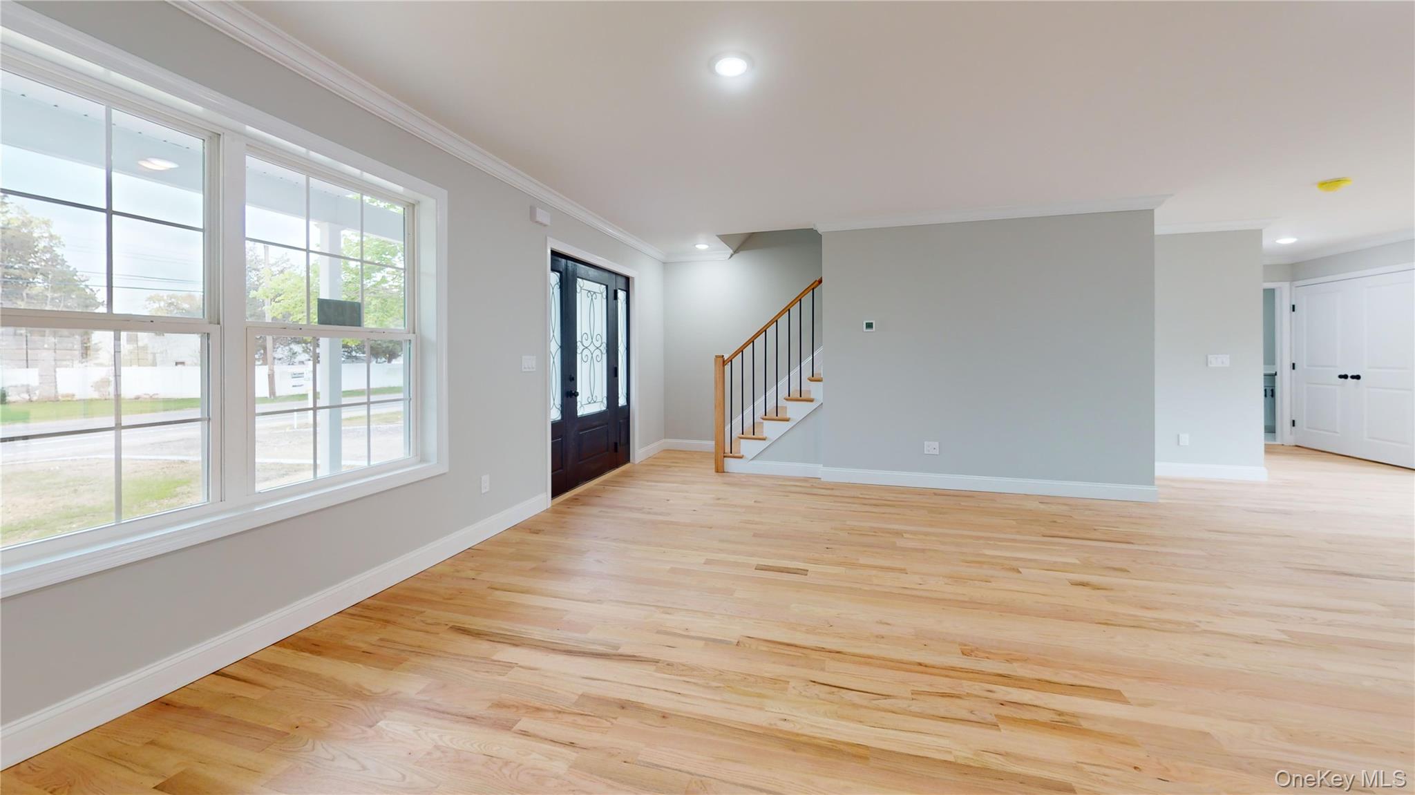 492 Blue Point Road Farmingville, NY 11738 - Photo 5 of 21 a view of an empty room with wooden floor and a window