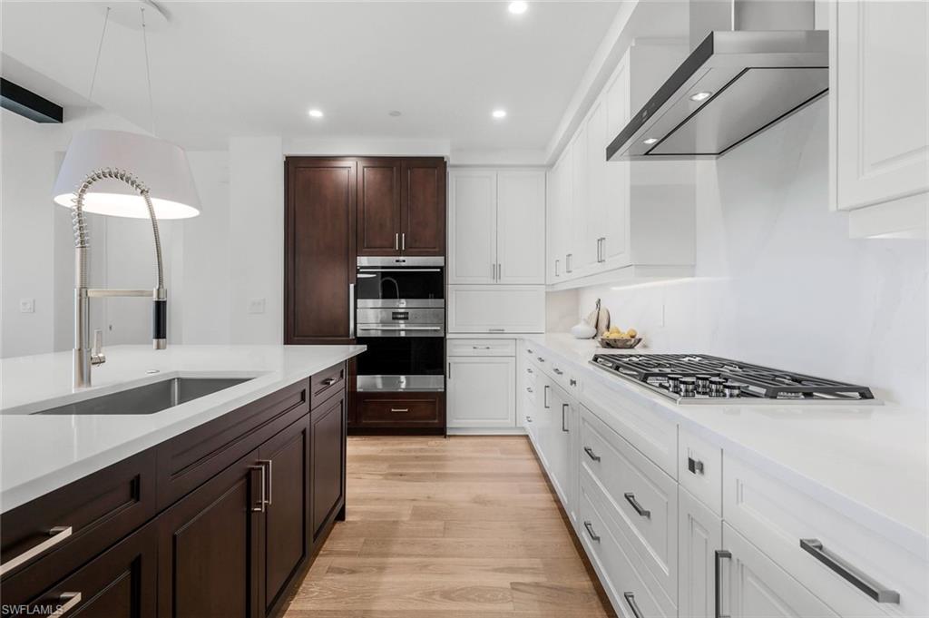 1130 3rd Avenue South, Unit 211 Naples, FL 34102 - Photo 11 of 33 a large kitchen with stainless steel appliances granite countertop a stove and a sink