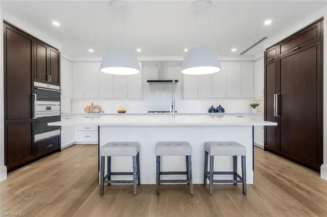 a kitchen with stainless steel appliances a sink cabinets and wooden floor