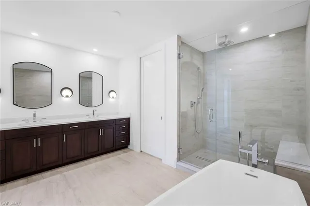 a spacious bathroom with a double vanity sink double mirror and bathtub