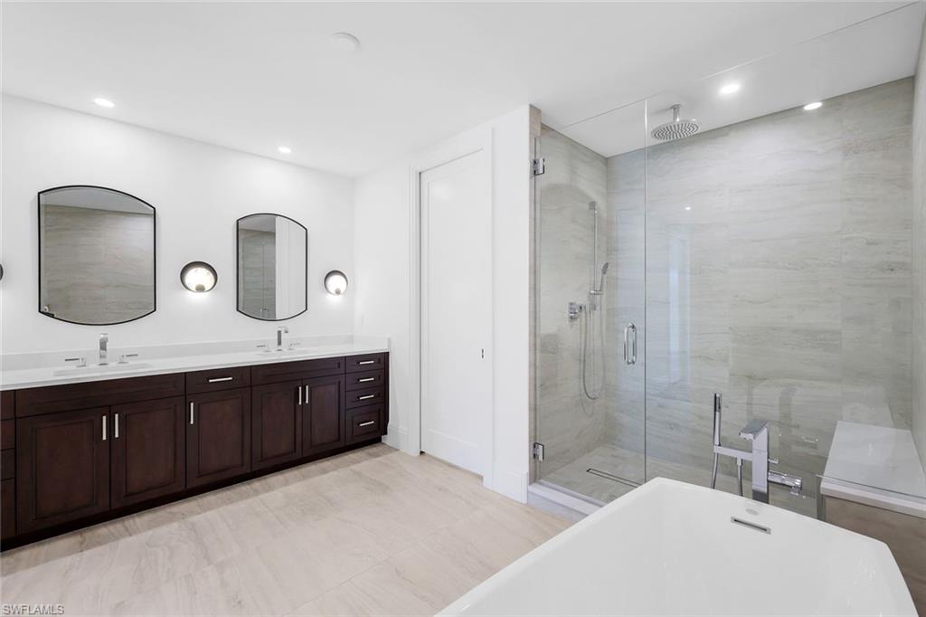 1130 3rd Avenue South, Unit 211 Naples, FL 34102 - Photo 14 of 33 a spacious bathroom with a double vanity sink double mirror and bathtub