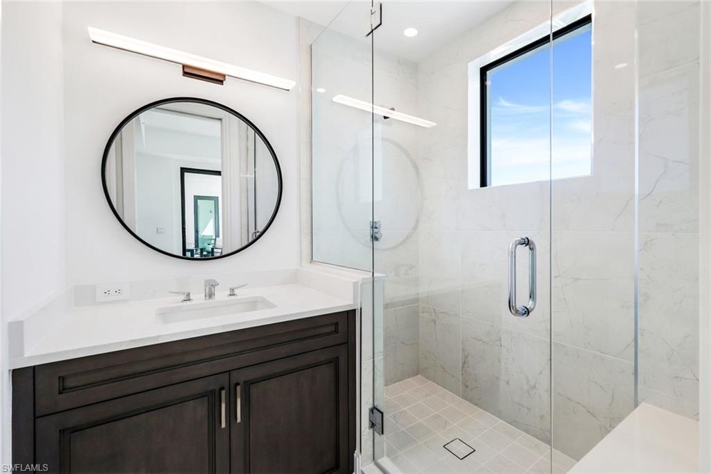 1130 3rd Avenue South, Unit 211 Naples, FL 34102 - Photo 16 of 33 a bathroom with a sink a toilet and a mirror