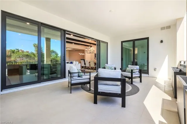 a living room with furniture and a floor to ceiling window