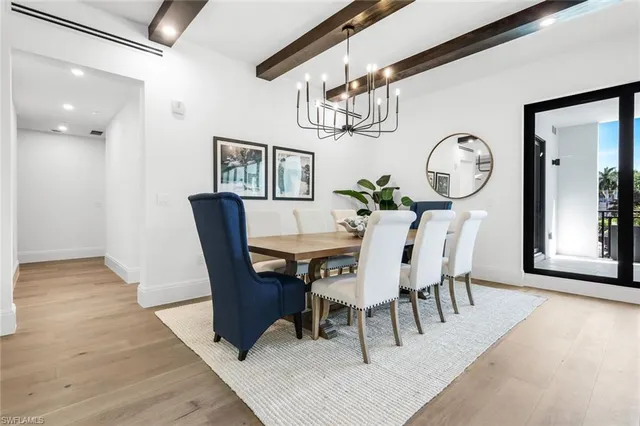 a view of a dining room with furniture a chandelier and wooden floor