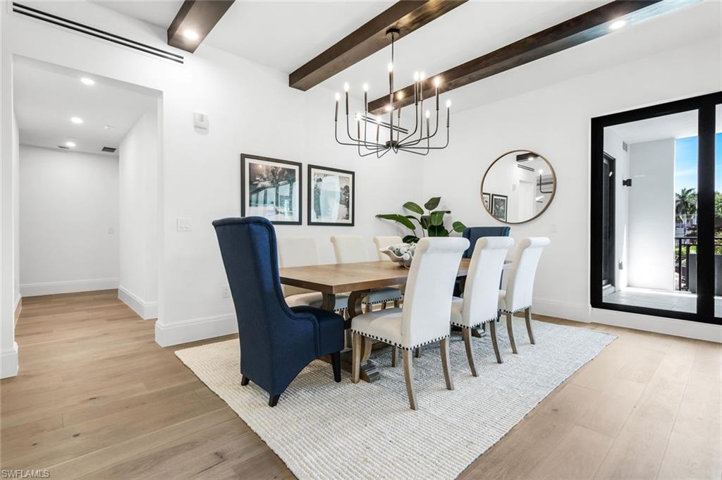 1130 3rd Avenue South, Unit 211 Naples, FL 34102 - Photo 5 of 33 a view of a dining room with furniture a chandelier and wooden floor