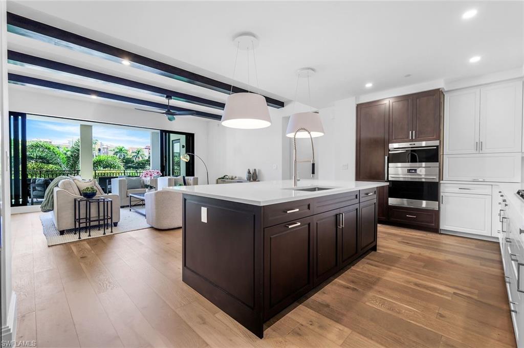 1130 3rd Avenue South, Unit 211 Naples, FL 34102 - Photo 8 of 33 a large kitchen with stainless steel appliances kitchen island granite countertop a large counter top and stainless steel appliances