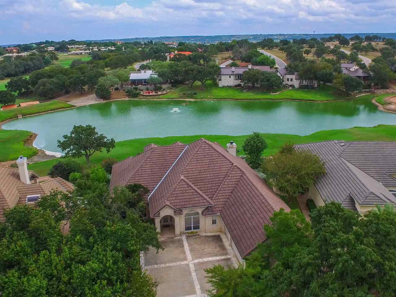 an aerial view of a house with a garden and a lake view