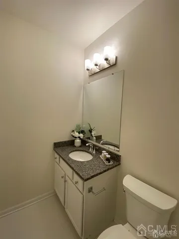 a bathroom with a granite countertop toilet and sink