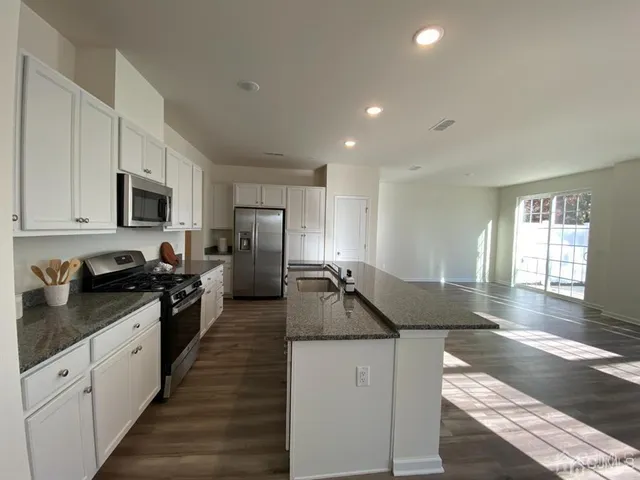 a kitchen with granite countertop lots of counter top space and stainless steel appliances