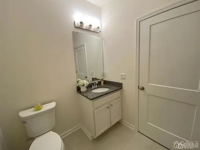 a bathroom with a toilet a sink and mirror