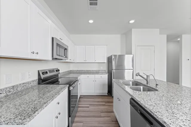 a kitchen with stainless steel appliances granite countertop a sink stove and refrigerator