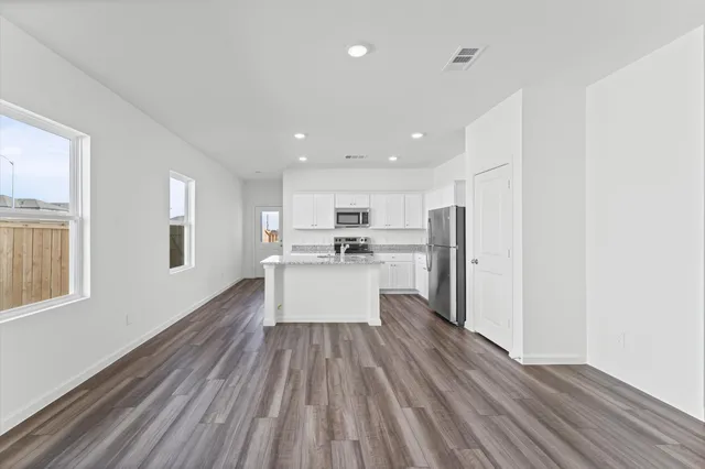 a view of kitchen with wooden floor and electronic appliances