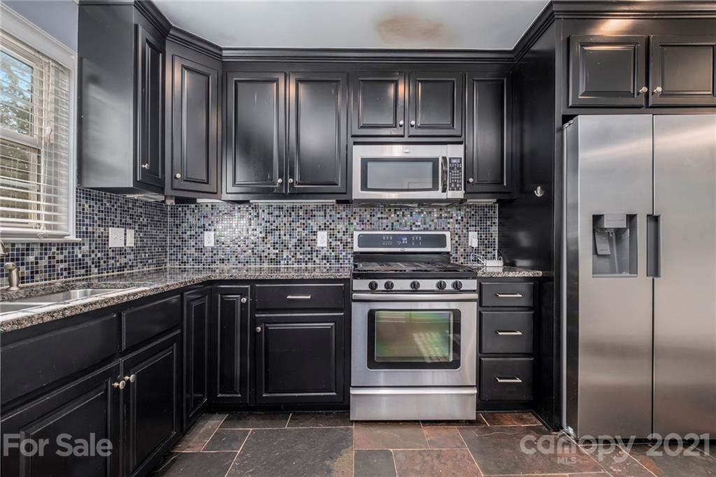 4211 Murrayhill Road Charlotte, NC 28209 - Photo 4 of 18 a kitchen with stainless steel appliances granite countertop a refrigerator and a sink