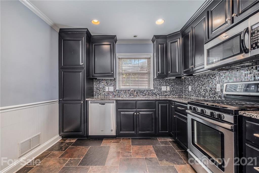 4211 Murrayhill Road Charlotte, NC 28209 - Photo 8 of 18 a kitchen with stainless steel appliances granite countertop a sink stove and refrigerator