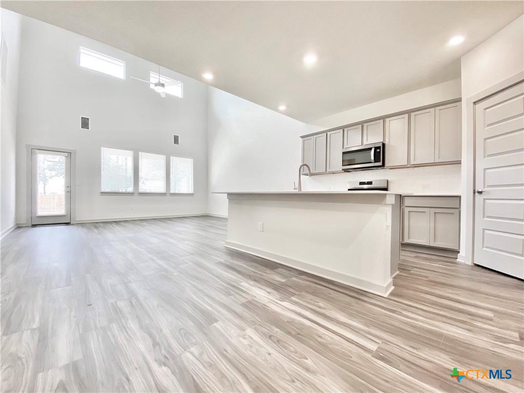 100 Geminiflora Bend Leander, TX 78641 - Photo 12 of 38 a view of kitchen with wooden floor and electronic appliances