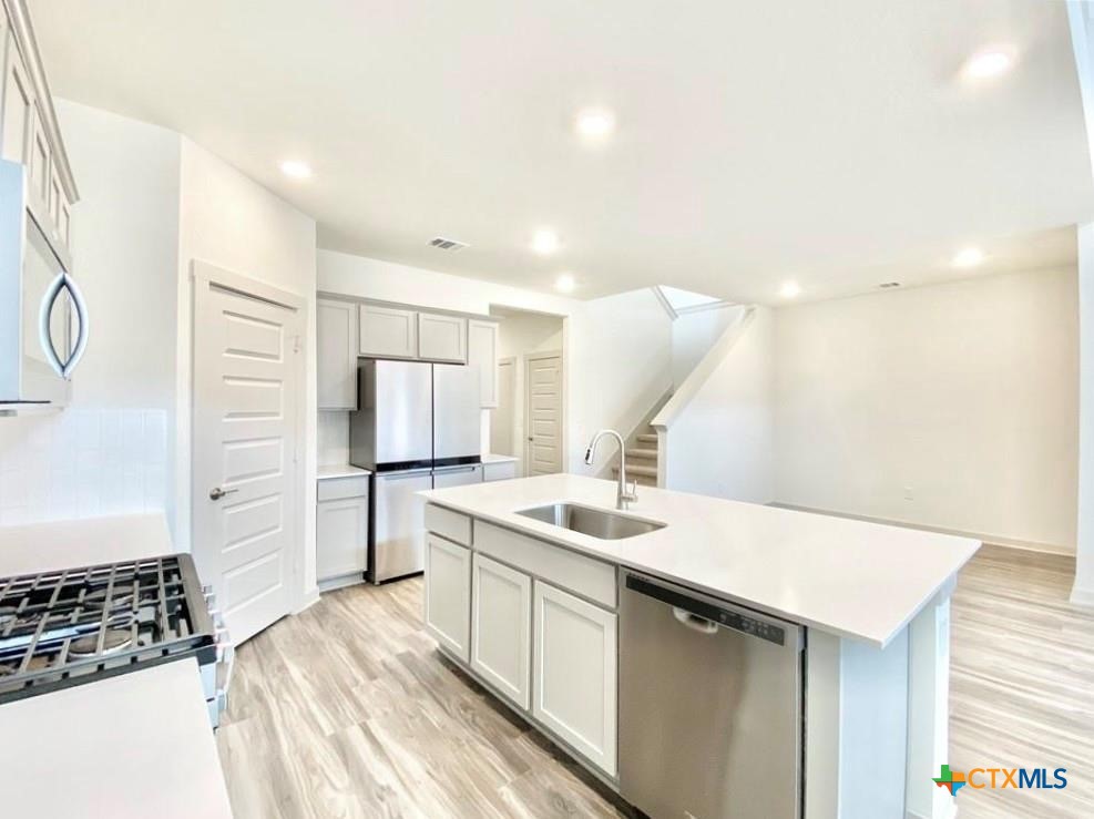 100 Geminiflora Bend Leander, TX 78641 - Photo 13 of 38 a kitchen with a sink stove and refrigerator