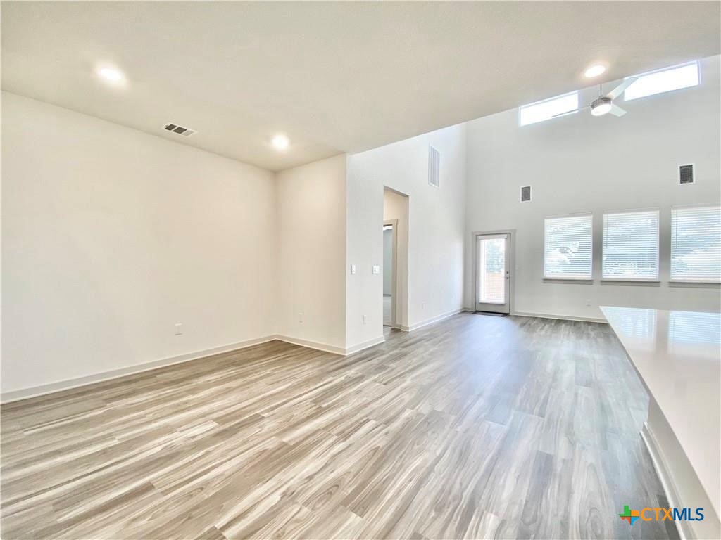 100 Geminiflora Bend Leander, TX 78641 - Photo 15 of 38 an empty room with wooden floor and windows