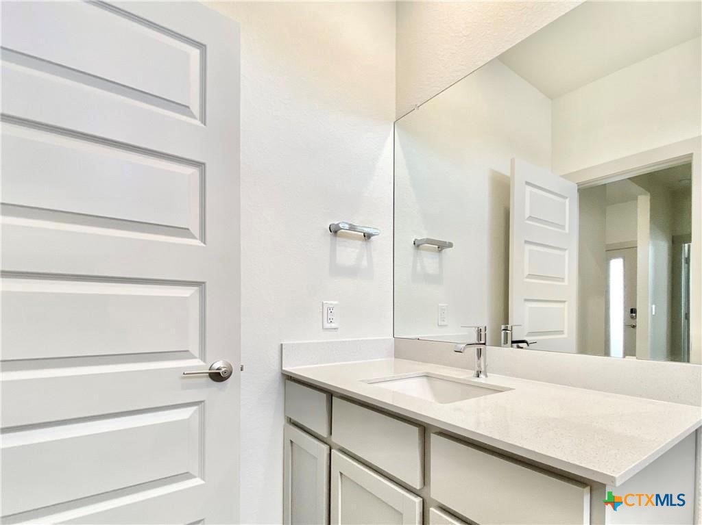 100 Geminiflora Bend Leander, TX 78641 - Photo 23 of 38 a bathroom with a granite countertop sink and a mirror